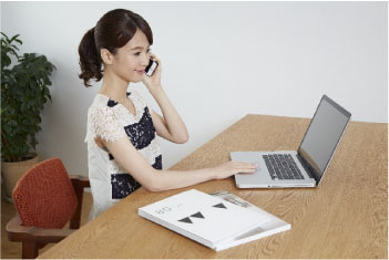 電話で問合せをしている女性